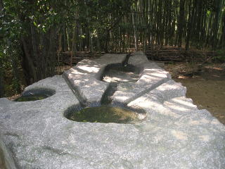 酒船石。上部には円形・楕円形が彫られており、それらを溝が繋いでいる。